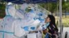 Seorang petugas kesehatan sedang melakukan tes usap pada seorang warga menyusul wabah virus corona (Covid-19) yang merebak kembali di Beijing, China, 20 Juni 2020.