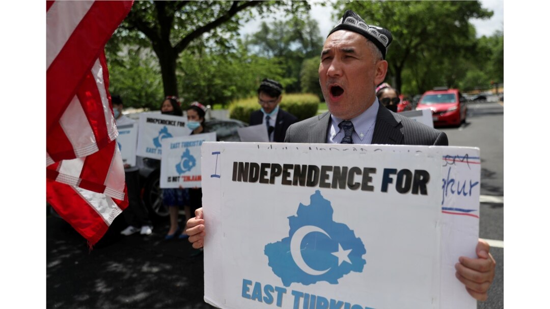FILE - Demonstrators hold a protest in front of the State Department to urge the U.S. and the international community to take action against China's treatment of the Uyghur people, May 5, 2021.