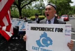 FILE - Demonstrators hold a protest in front of the State Department to urge the U.S. and the international community to take action against China's treatment of the Uyghur people, May 5, 2021.