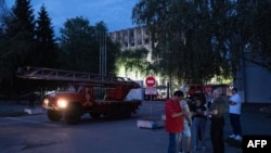 Local residents wait outside a military educational facility after it was hit by Russian missiles in Poltava, eastern Ukraine on Sept. 3, 2024.