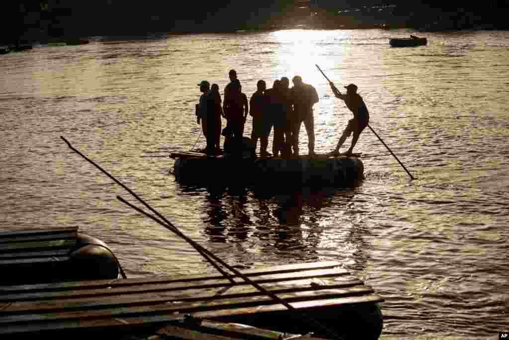 People across the Suchiate River between Tecun Uman, Guatemala, right, and Ciudad Hidalgo, Mexico, on a raft. 