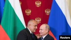 FILE - Russian President Vladimir Putin and Bulgarian Prime Minister Boyko Borissov hug after a joint news conference following their talks at the Kremlin in Moscow, Russia, May 30, 2018.