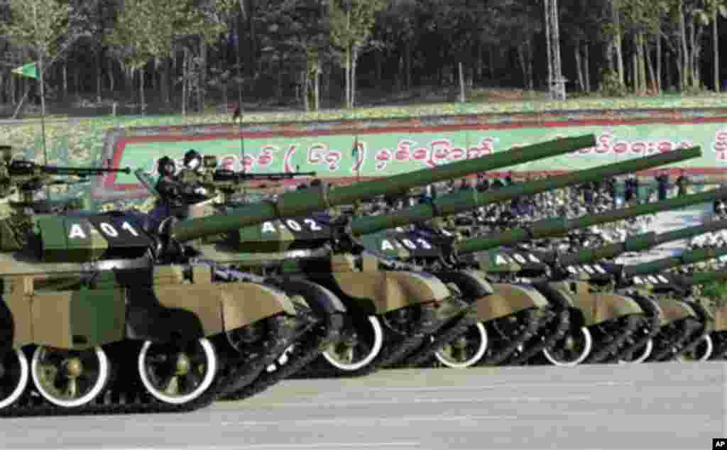 Myanmar military soldiers salute from tanks as they leave the venue during a ceremony to mark the 67th anniversary of the country's Independence Day in Naypyitaw, Myanmar Sunday, Jan. 4, 2015. (AP Photo/Khin Maung Win)