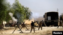 Members of Iraqi Army fire mortar shells during the war between Iraqi army and Shi'ite Popular Mobilization Forces (PMF) against the Islamic State militants in al-Ayadiya, northwest of Tal Afar, Iraq, Aug. 28, 2017. 