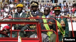 Zimbabwe's President Robert Mugabe (2nd R) arrives at the 32nd anniversary celebrations of the Zimbabwe Defense Forces Day at the National Sports stadium, in Harare, August 14, 2012.