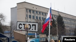 Manifestan pwo-Larisi ap sikile bò kote yon barikad devan katye jeneral lapolis la nan vil Luhansk, nan pati lès Ikrèn. (Foto: 10 avril 2014).