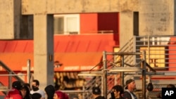 People congregate without face masks in a closed area of Muscle Beach Venice in Venice Beach in Los Angeles, Dec. 27, 2020.