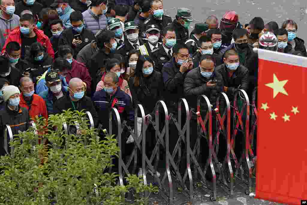 Airport workers wearing face masks wait for COVID-19 testing at the Shanghai Pudong International Airport in Shanghai, China.