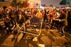 Los manifestantes pro Vizcarra derriban una barricada impuesta por la policía en Lima, el viernes 13 de noviembre de 2020.