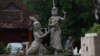 A man walks pass by a statue of Moni Mekhala, goddess of the seas, and Ream Eyso, storm demon, inside Royal University of Fine Art on May 28, 2015. (Nov Povleakhena/VOA Khmer)