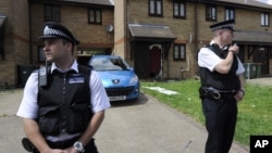 Police officers outside home raided in Stratford, east London, July 5, 2012.