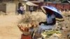 A woman roasts maize by the road side along Manchock road, in Kaura Local Government Kaduna State, Nigeria, March 21, 2014. 