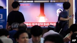 People watch a TV showing a file image of North Korea's missile launch during a news program at the Seoul Railway Station in Seoul, South Korea, July 31, 2019. 