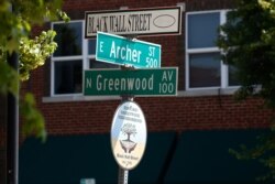 FILE - A sign marks the intersection of Greenwood Avenue and Archer Street, the former home of Black Wall Street, in Tulsa, Okla., June 15, 2020.