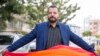 LGBT activist Mounir Baatour holds a rainbow flag after submitting his candidacy for the upcoming early presidential elections in Tunis, Tunisia. Thursday, Aug. 8, 2019. 