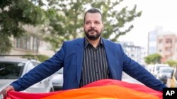 LGBT activist Mounir Baatour holds a rainbow flag after submitting his candidacy for the upcoming early presidential elections in Tunis, Tunisia. Thursday, Aug. 8, 2019. 
