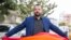 LGBT activist Mounir Baatour holds a rainbow flag after submitting his candidacy for the upcoming early presidential elections in Tunis, Tunisia. Thursday, Aug. 8, 2019. 