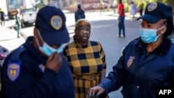 Une femme proteste après avoir été gazée par un membre des services de police sud-africains pour ne pas avoir porté de masque facial à Hillbrow, Johannesburg le 1er mai 2020.