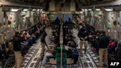 This image released by the Department of Defense shows undocumented migrants awaiting takeoff for a removal flight at the Tucson International Airport, Arizona, Jan. 23, 2025. (AFP photo/DVIDS/Department of Defense/Senior Airman Devlin Bishop)