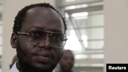 Tanzanian investigative journalist Erick Kabendera listens to his lawyers as he sits inside the Kisutu Resident Magistrate's Court in Dar es Salaam, Tanzania November 20, 2019.