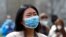 A demonstrator wearing a mask saying "I am not a virus" listens to a speech at a rally against Asian hate crimes, March 27, 2021 at Chicago's Grant Park. 