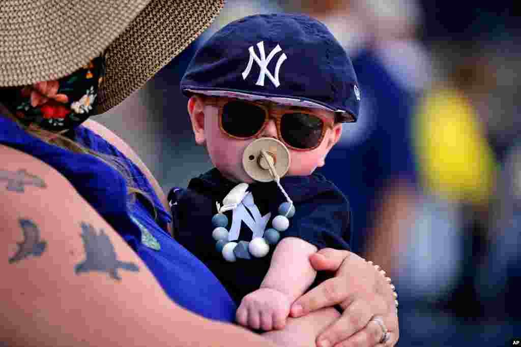 미국 프로야구 구단인 뉴욕 양키스 팬이 6개월된 아이를 안고 플로리다 템파에서 열린 필라델피아 필리스와의 시범경기를 관람하고 있다. 
