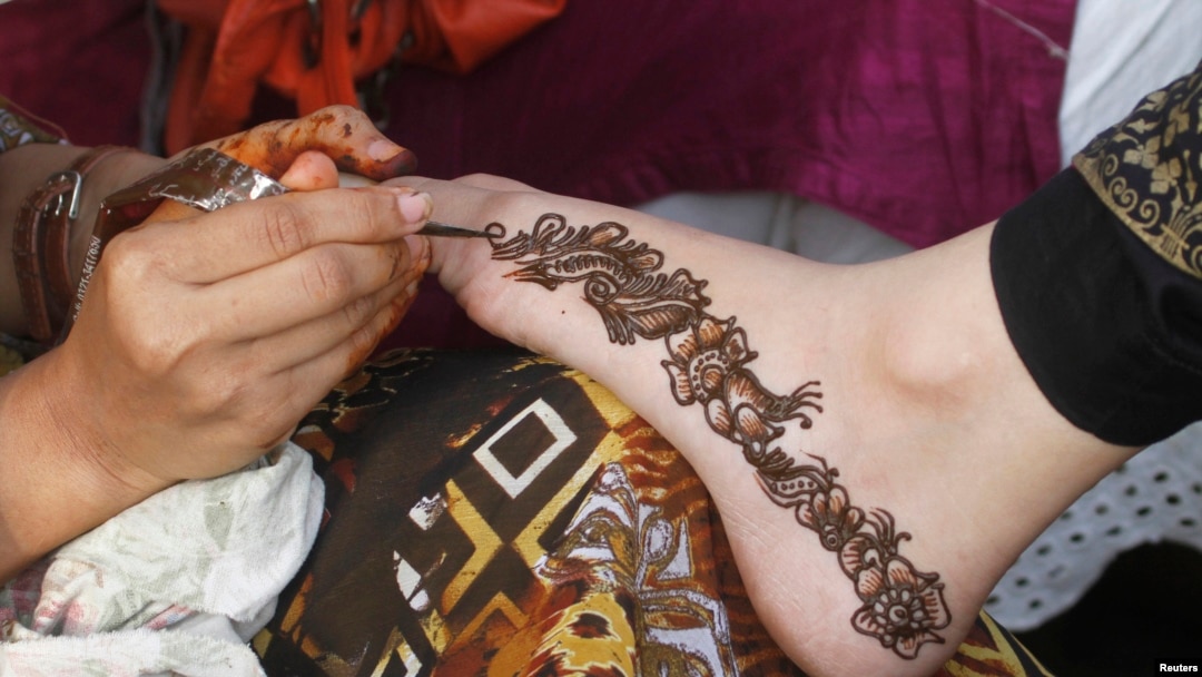 Chuyên viên thẩm mỹ trang điểm tay một khách hàng để chuẩn bị cho lễ hội Hồi giáo Eid al-Fitr ở thành phố Karachi, Pakistan. 