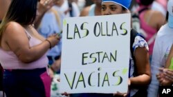 Un manifestante sostiene un cartel que dice "Las ollas están vacías" durante una manifestación contra las reformas económicas del gobierno frente a la residencia presidencial de Olivos en Buenos Aires, Argentina, el martes 23 de enero de 2024. 