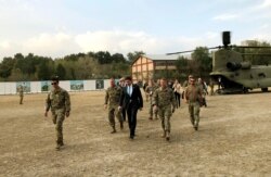 FILE - U.S. Defense Secretary Mark Esper, center, walks with Gen. Scott Miller, (r), chief of the U.S.-led coalition in Afghanistan, at the U.S. military headquarters in Kabul, Oct. 20, 2019.