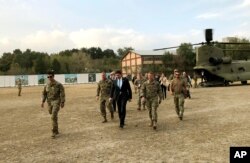 FILE - U.S. Defense Secretary Mark Esper, center, walks with Gen. Scott Miller, (r), chief of the U.S.-led coalition in Afghanistan, at the U.S. military headquarters in Kabul, Oct. 20, 2019.
