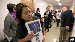 Teamster member Rocio Mejia, a supporter of a proposal to raise the state's minimum wage, joins others outside the Assembly Chambers calling for Assembly members to approve the measure, March 31, 2016, in Sacramento, California.