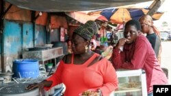 Funmilayo Oresanya, a road side food seller, dishes out rice in a plastic container at Obalende in Lagos, Nigeria on January 23, 2024.