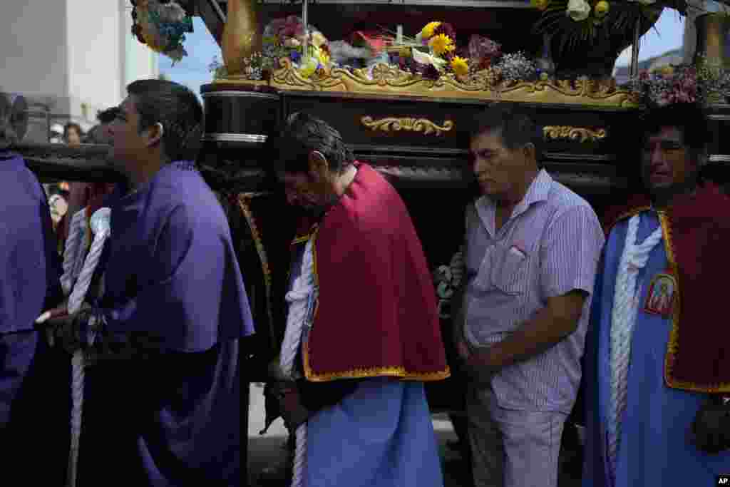 Pescadores van en procesión detrás de la representación de San Pedro, transportada en un bote, en el centro, como parte de la procesión por el océano Pacífico en honor del santo patrón católico de los pescadores en el día de su festividad en Pucusana, Perú, el jueves 29 de junio de 2023.