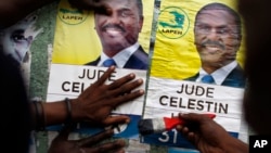 People put up campaign posters promoting presidential candidate Jude Celestin in Petionville, Haiti, Nov. 18, 2016.