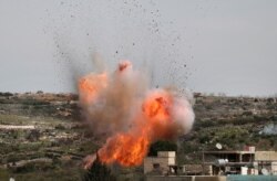 An explosion is seen following Russian airstrikes on the village of al-Bara in the southern part of Syria's northwestern Idlib province, March 5, 2020.