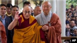 The Dalai Lama gestures as he arrives to give a religious talk at the Tsuglakhang temple in Dharamsala, India, Oct. 23, 2011.