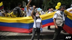 People wave the Colombian national flag during a demonstration in opposition to road blockades and violence, after a month of national protests, in Bogota, on May 30, 2021. 