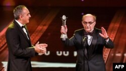Egyptian film critic Youssef Cherif Rizkallah (R) appears on-stage with Cairo International Film Festival (CIFF) President, as Rizkallah receives an award at the opening ceremony of the festival's 40th edition at the Cairo Opera House, Nov. 20, 2018. 