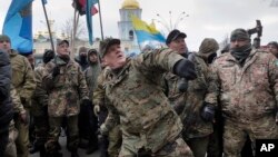 Mykola Kokhanivsky, commander of a volunteer battalion, throws a stone against the window of an office that belongs to Ukraine tycoon Rinat Akhmetov in Kyiv, Feb. 20, 2016. The activists blame Akhmetov for supporting corruption and pro-Russian separatists