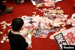 FILE - Pork intestines and other organs are seen on the ground after Taiwan lawmakers threw the parts at each other during a scuffle in the parliament in Taipei, Taiwan, Nov. 27, 2020.