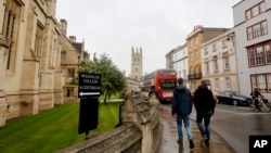 FILE - People walk around Oxford University's campus in Oxford, England on Sept. 3, 2017. 