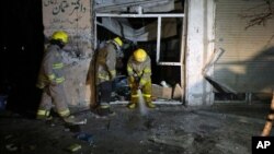 Afghan firefighters spray water at the site of a suicide attack targeting parliamentarian Gul Pacha Mujedi in Kabul, Afghanistan, March 29, 2015. 