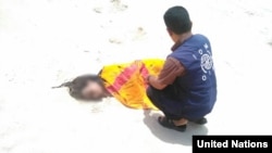 UN Migration Agency staff tend to the remains of a deceased migrant on a beach in Yemen.