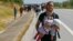 A Syrian migrant carries a baby as he walks towards the Greece border on a road near Edirne, Turkey, Sept. 15, 2015. 