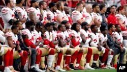 Members of the San Francisco 49ers kneel during the national anthem as others stand during the first half of an NFL football game against the Arizona Cardinals, Oct. 1, 2017, in Glendale, Arizona.