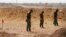 FILE - Mine clearers search for mines and explosive devices at Hammam al-Alil city, south of Mosul, Iraq, July 29, 2017.   