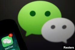 FILE PHOTO: The messenger app WeChat is seen next to its logo in this illustration picture taken Aug. 7, 2020.