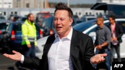 (FILES) In this file photo taken on September 03, 2020, Tesla CEO Elon Musk arrives to visit the construction site of the future US electric car giant Tesla in Gruenheide near Berlin. - Musk says he has tested positive for the novel coronavirus…