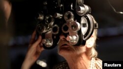 FILE - A man receives an eye exam at the Remote Area Medical Clinic in Wise, Virginia, July 22, 2017. 