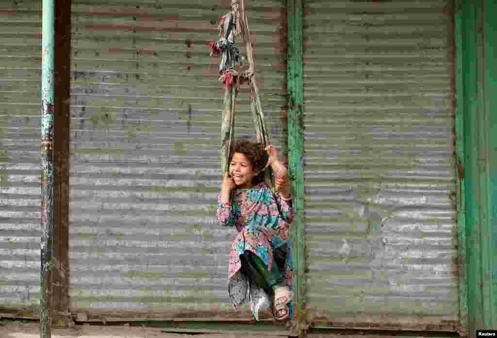 A girl plays on a swing in Kabul, Afghanistan.